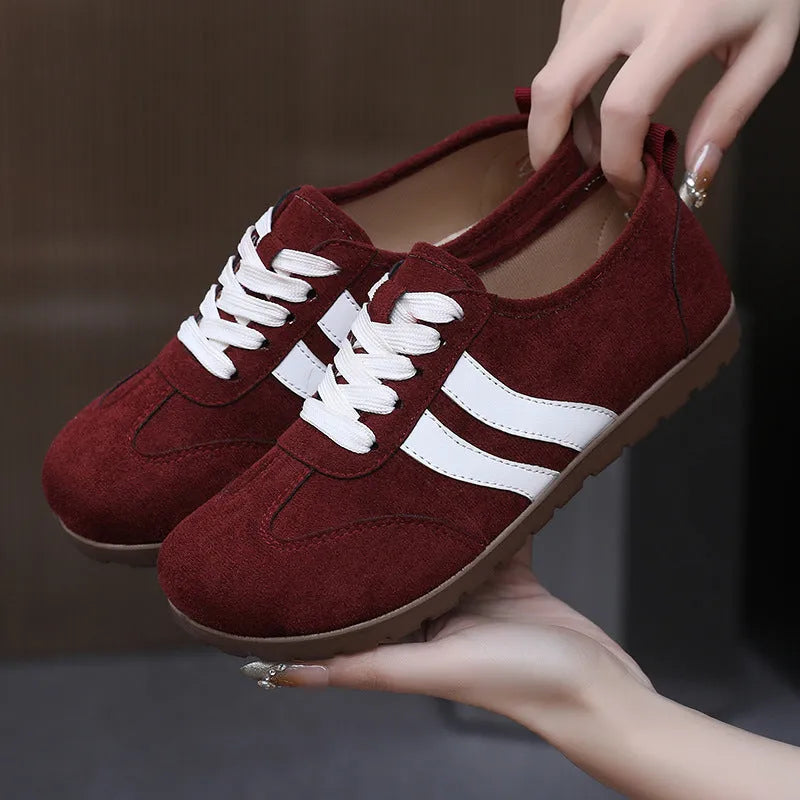Women's vintage canvas sneakers in dark red with a round toe and flat rubber sole.