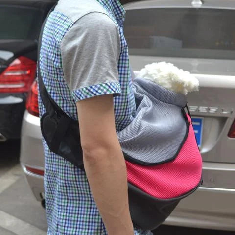 A comfortable and stylish pet sling bag with padded mesh and leather details, allowing hands-free travel for pet owners.