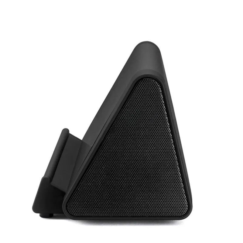 Compact black or white wireless Bluetooth speaker with charging cable.