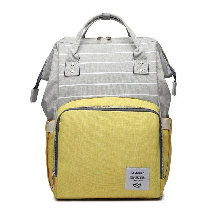 Stylish maternity diaper bag in various colors, featuring a paper bag design, separate bottle compartment, and discreet breastfeeding button.