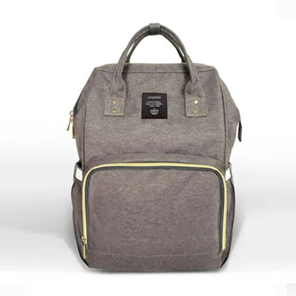 Stylish maternity diaper bag in various colors, featuring a paper bag design, separate bottle compartment, and discreet breastfeeding button.