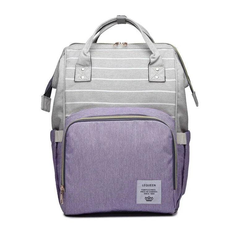 Stylish maternity diaper bag in various colors, featuring a paper bag design, separate bottle compartment, and discreet breastfeeding button.