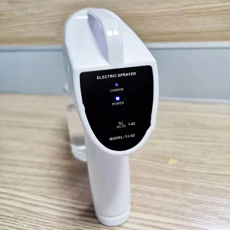 White handheld cordless electric spray disinfection gun with USB-C port and trigger, showing mist spray.