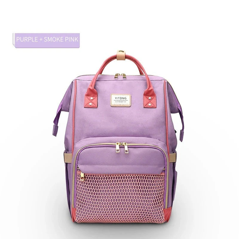 Stylish maternity diaper bag in various colors, featuring a paper bag design, separate bottle compartment, and discreet breastfeeding button.