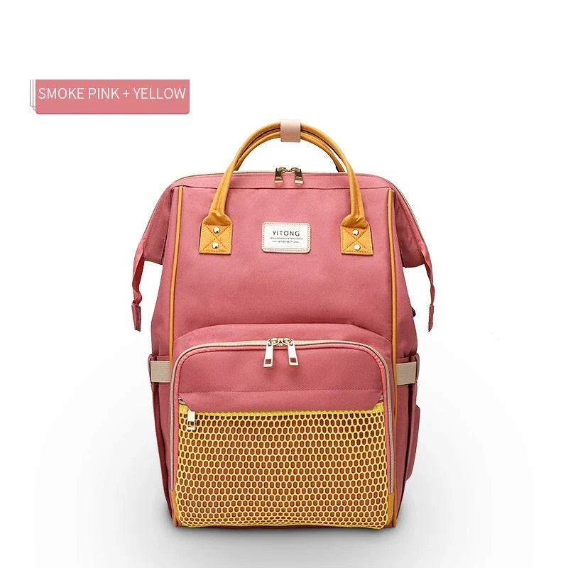 Stylish maternity diaper bag in various colors, featuring a paper bag design, separate bottle compartment, and discreet breastfeeding button.