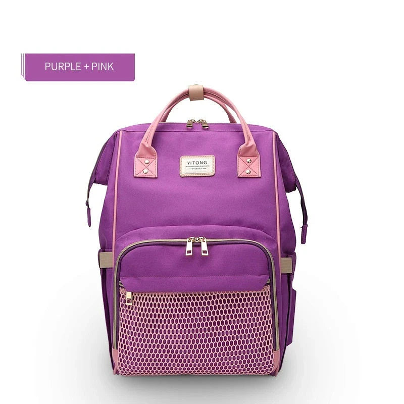 Stylish maternity diaper bag in various colors, featuring a paper bag design, separate bottle compartment, and discreet breastfeeding button.