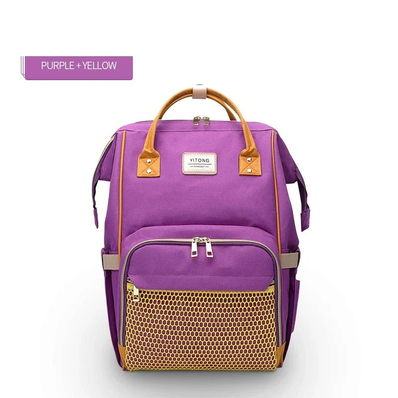 Stylish maternity diaper bag in various colors, featuring a paper bag design, separate bottle compartment, and discreet breastfeeding button.