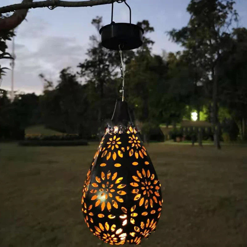 Elegant solar-powered garden lantern with a drop-shaped metal design and a soft, flower-patterned glow