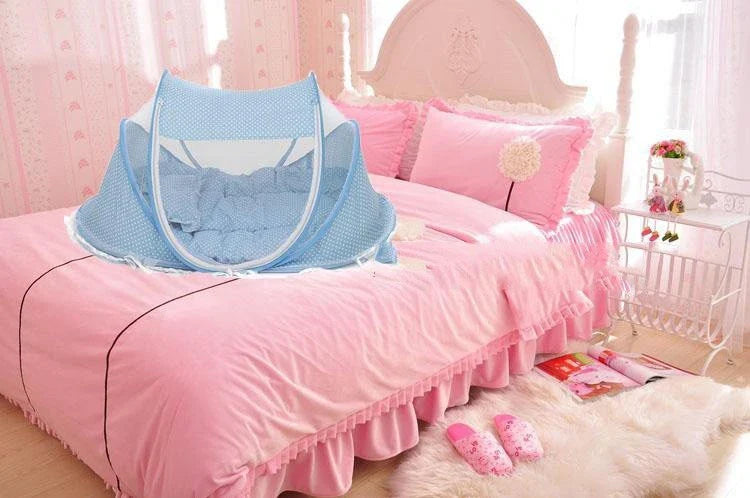 Breathable insect-free foldable baby travel cot with integrated mattress and pillow, available in blue, pink and blue-and-pink colour options