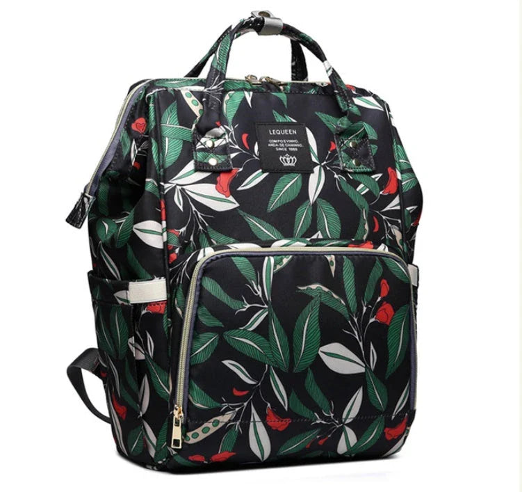 Stylish maternity diaper bag in various colors, featuring a paper bag design, separate bottle compartment, and discreet breastfeeding button.