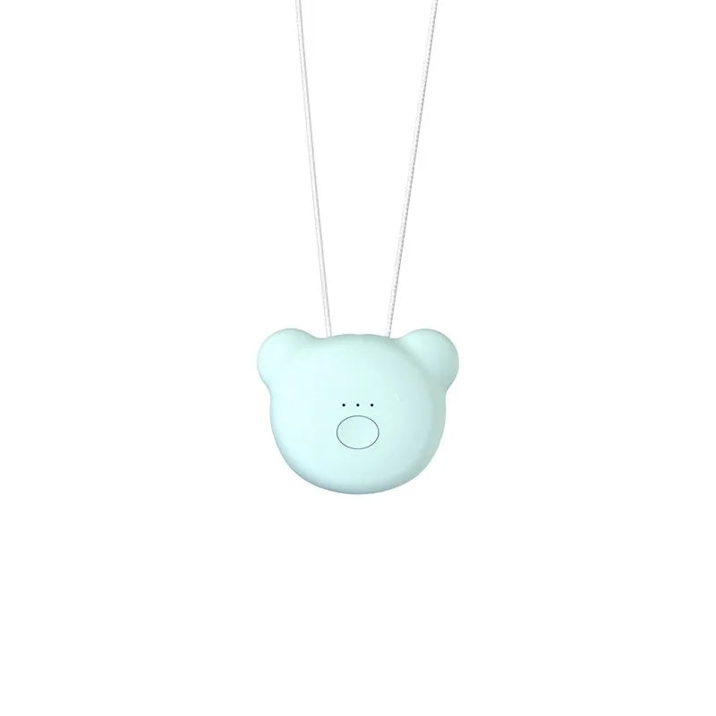 Compact pink USB air purifier necklace on a table with charging cable, showing dimensions 1.5 by 5.7 cm.
