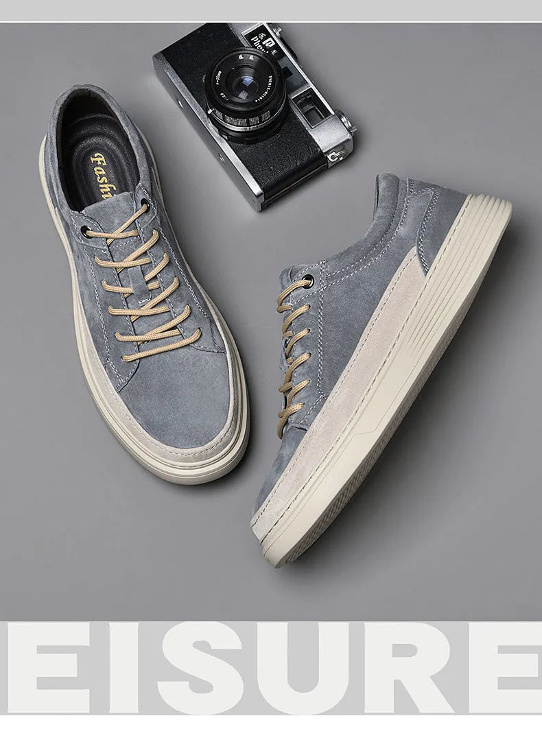 Men's grey low-top casual leather skate shoes with round toe and flat rubber sole on a neutral background.