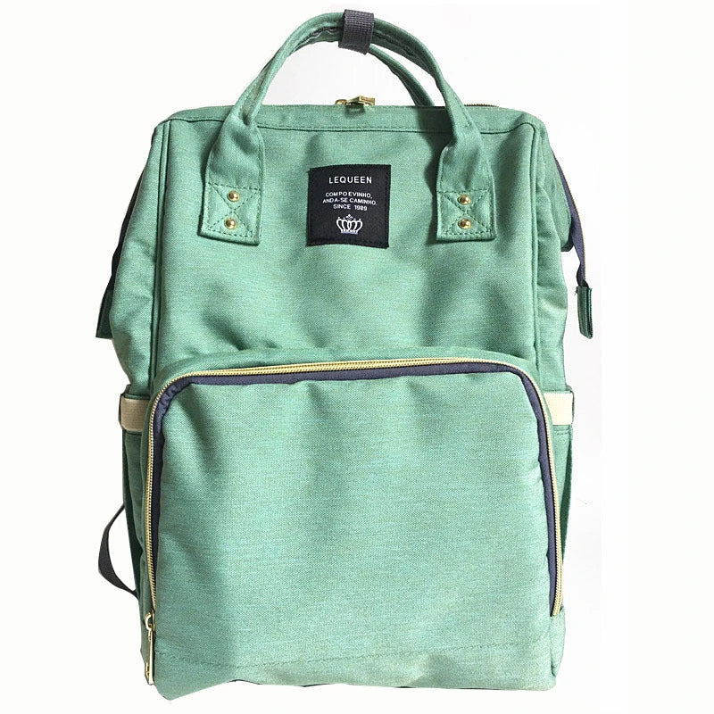 Stylish maternity diaper bag in various colors, featuring a paper bag design, separate bottle compartment, and discreet breastfeeding button.