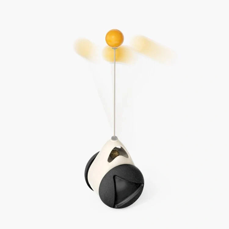 Cat playing with rotating windmill toy featuring luminous balls and suction base