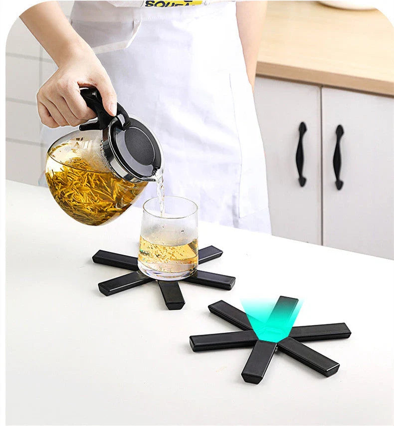 Foldable, heat-resistant pan mat made of sturdy ABS material with anti-slip and heat-insulating features to protect surfaces and hands