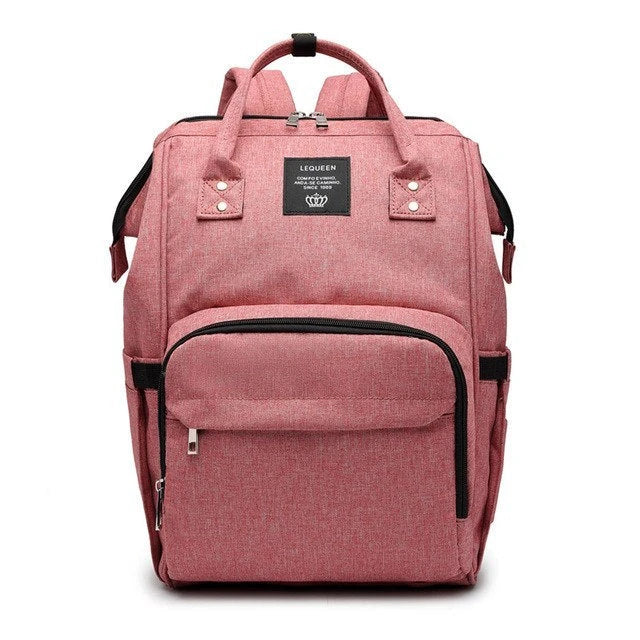 Stylish maternity diaper bag in various colors, featuring a paper bag design, separate bottle compartment, and discreet breastfeeding button.