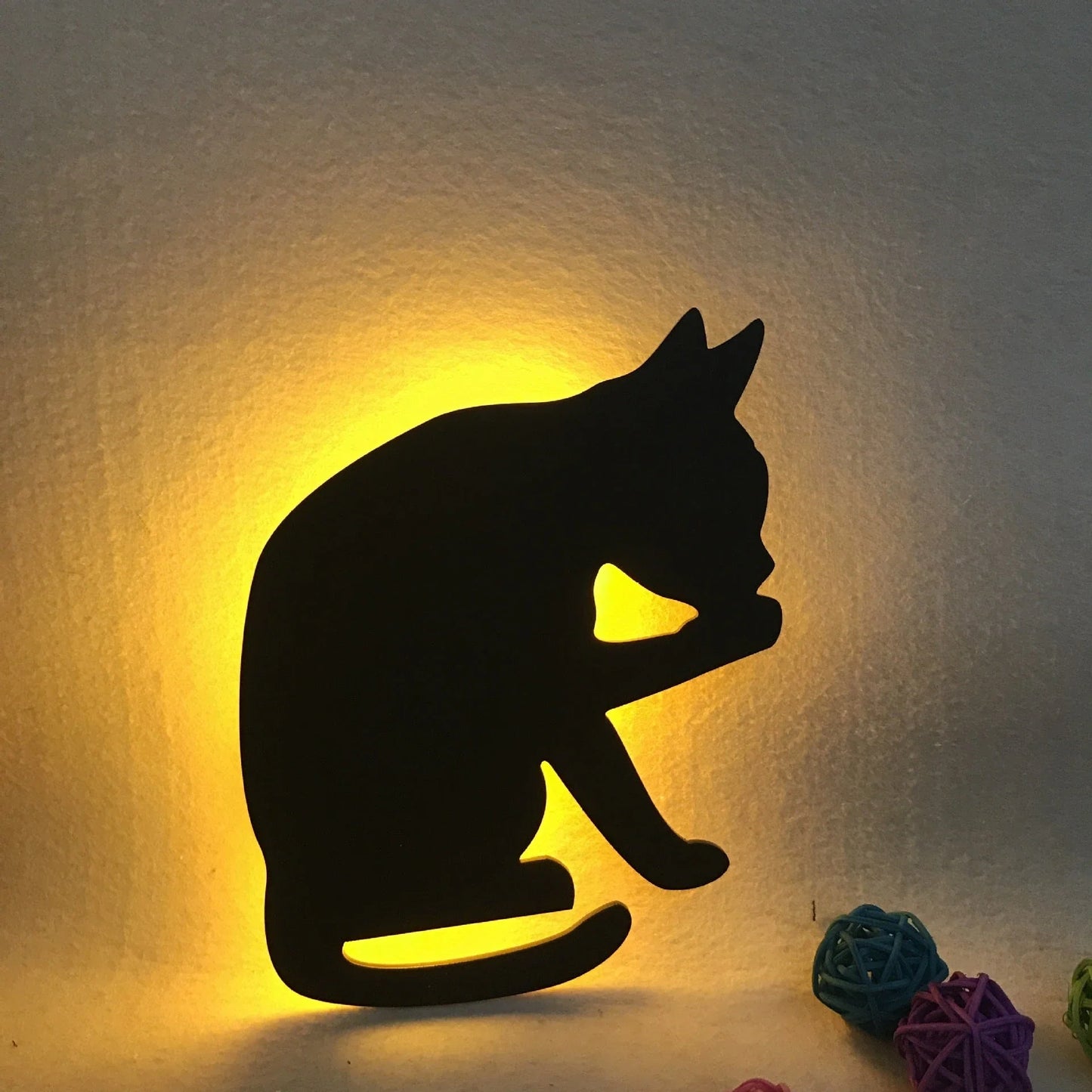 A stylish cat-themed LED lamp that automatically lights up when it detects sound, creating a cozy, ambient glow in a room.