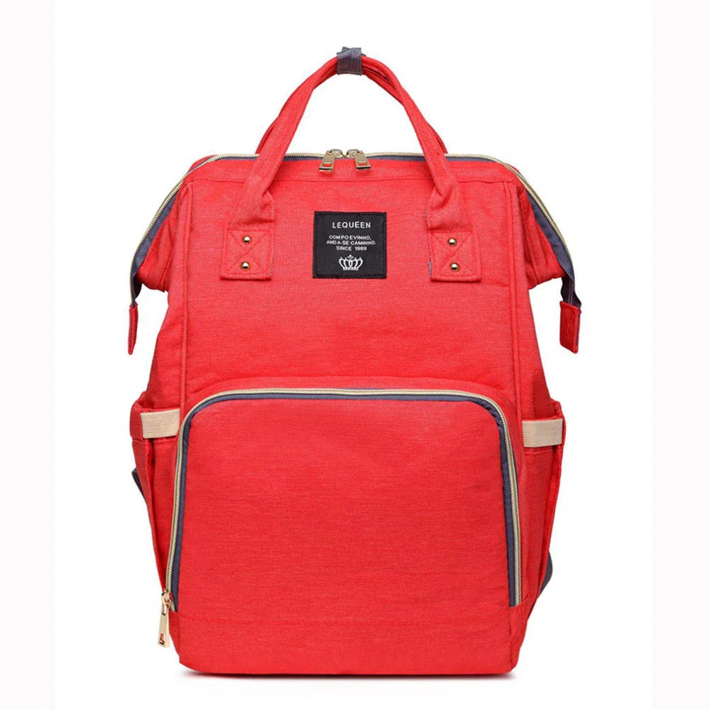 Stylish maternity diaper bag in various colors, featuring a paper bag design, separate bottle compartment, and discreet breastfeeding button.
