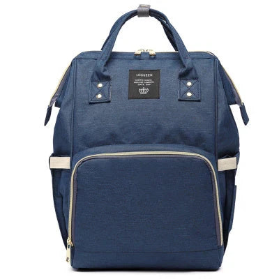 Stylish maternity diaper bag in various colors, featuring a paper bag design, separate bottle compartment, and discreet breastfeeding button.