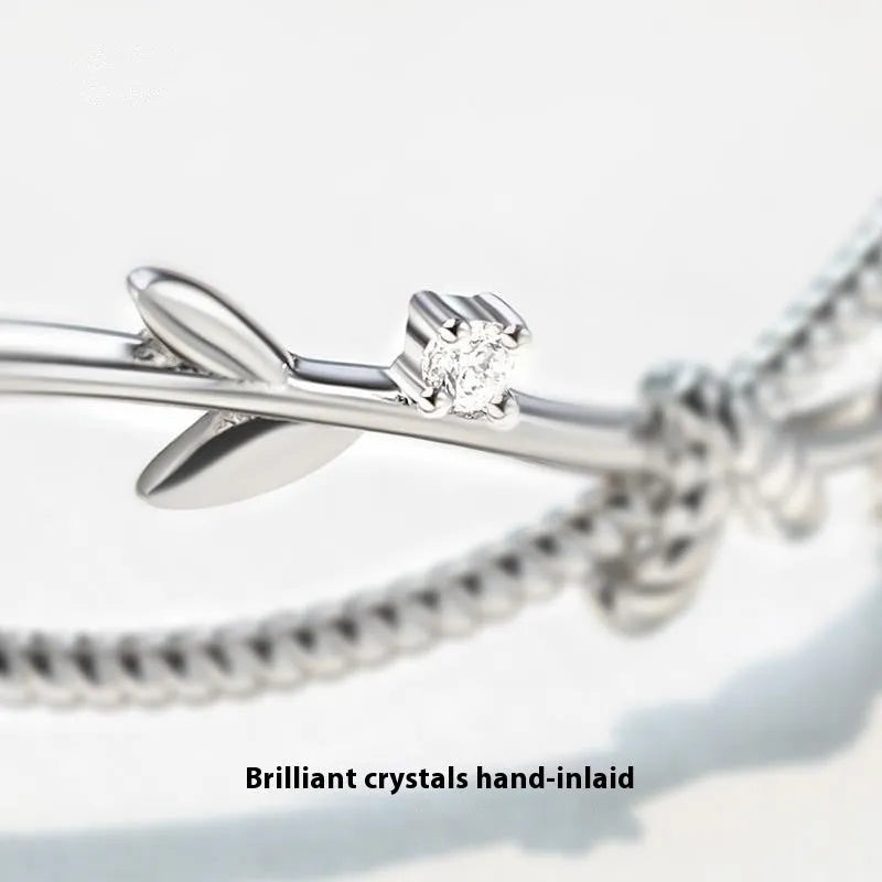 Copper ins style bracelet with detailed young tree branch and sprout cross twisted design in electroplated white gold colour.