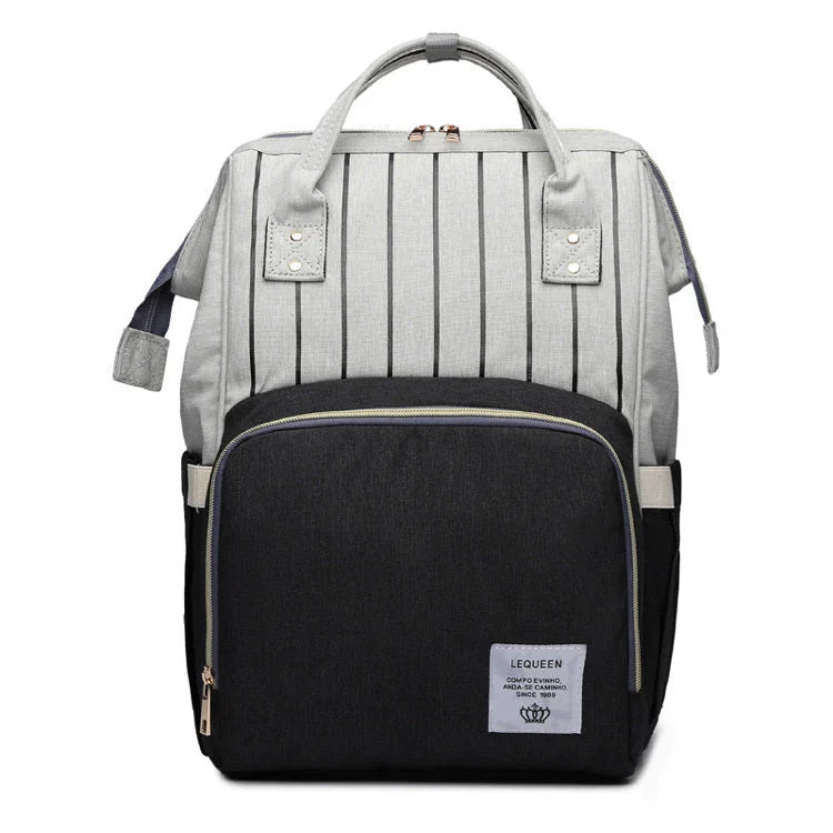 Stylish maternity diaper bag in various colors, featuring a paper bag design, separate bottle compartment, and discreet breastfeeding button.