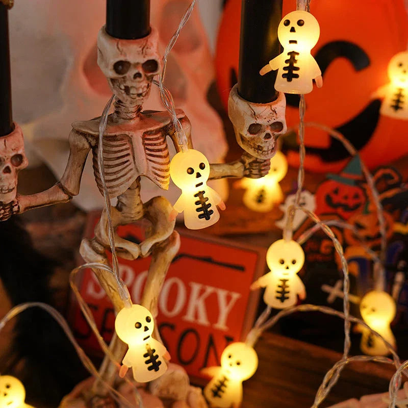 Battery-powered LED Halloween lights in various spooky designs including pumpkins, ghosts, and bats with warm white glow