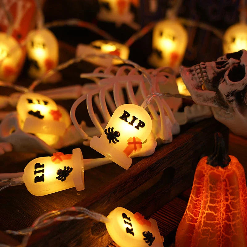 Battery-powered LED Halloween lights in various spooky designs including pumpkins, ghosts, and bats with warm white glow