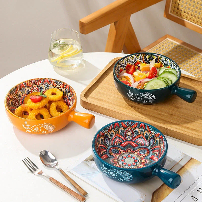 Elegant ceramic bowls with floral handles in blue, red, and green glazed finishes, perfect for serving salads and desserts