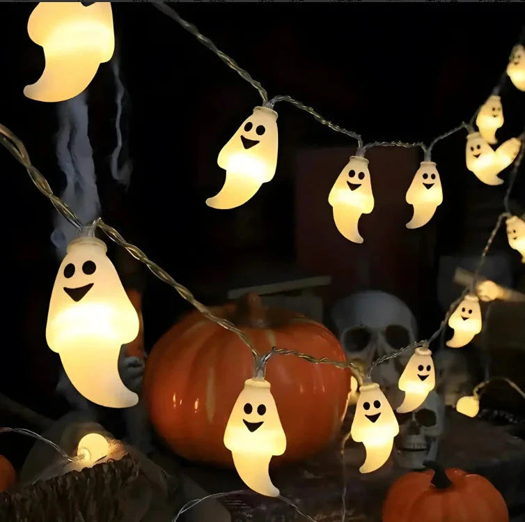 Battery-powered LED Halloween lights in various spooky designs including pumpkins, ghosts, and bats with warm white glow