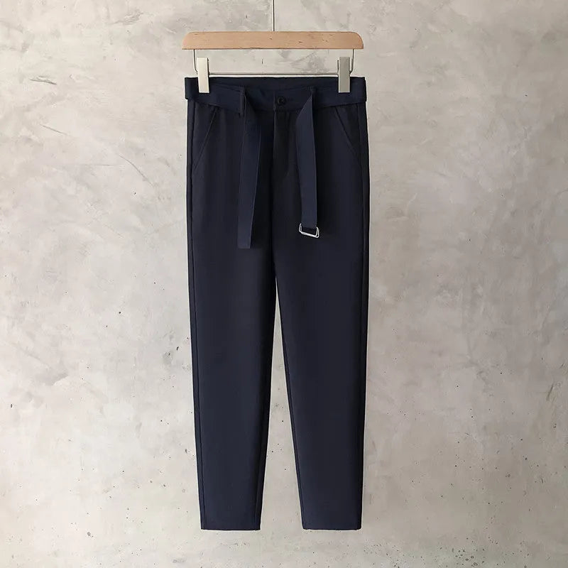 Boys slim straight wool trousers in tapered fit on hanger, showing straight leg opening.