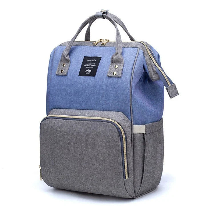 Stylish maternity diaper bag in various colors, featuring a paper bag design, separate bottle compartment, and discreet breastfeeding button.