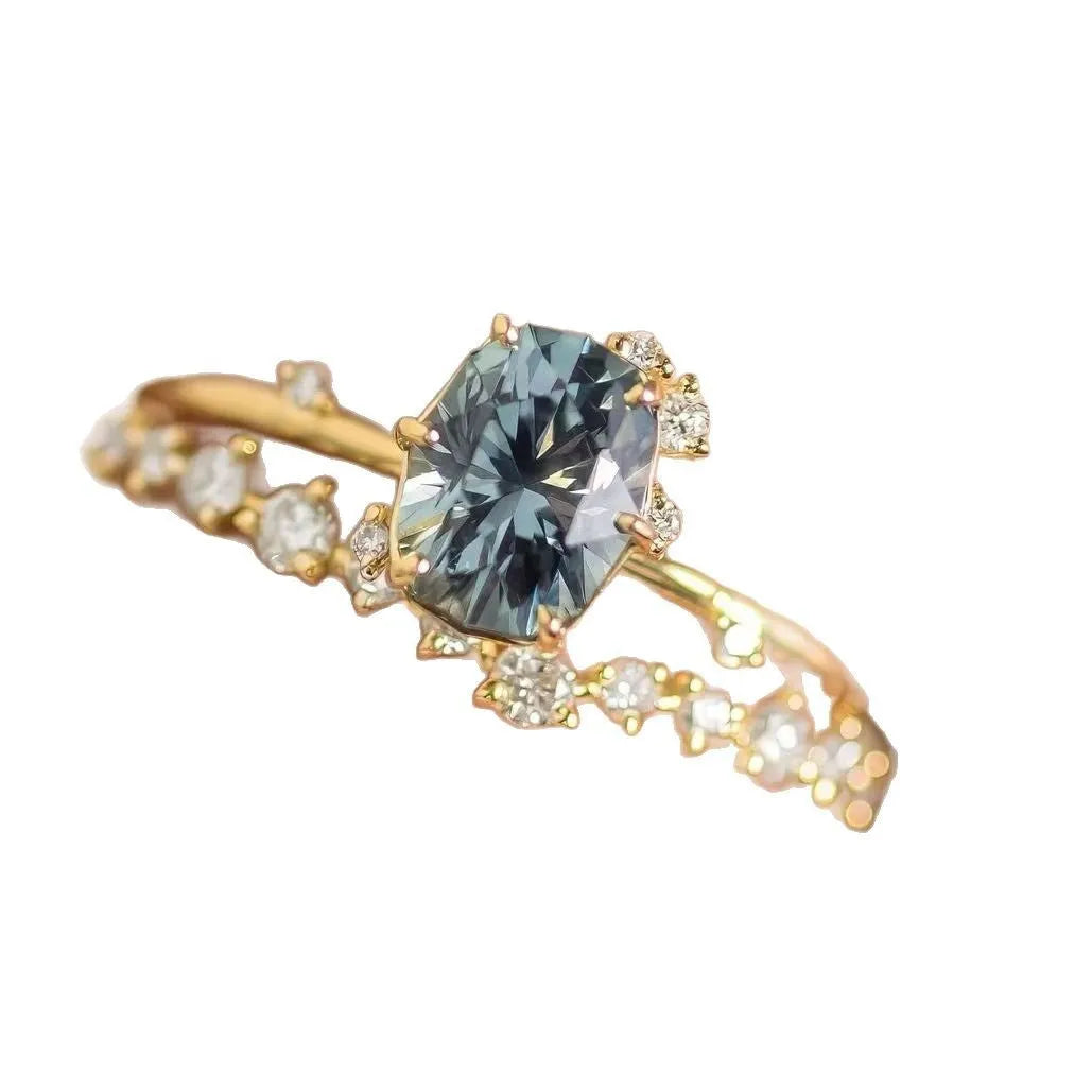 Gold-plated floral women's ring with a green zircon stone centrepiece on a model's hand.