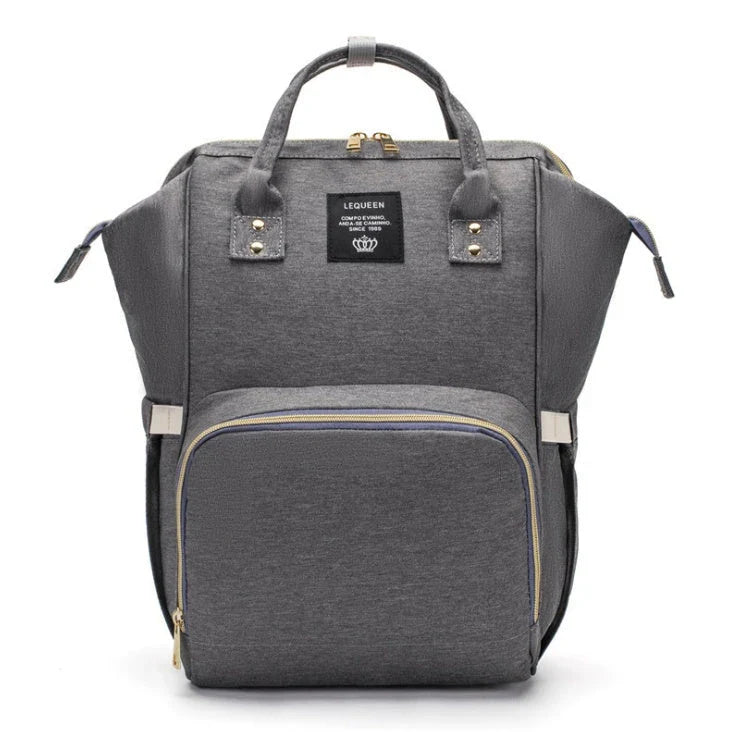 Stylish maternity diaper bag in various colors, featuring a paper bag design, separate bottle compartment, and discreet breastfeeding button.