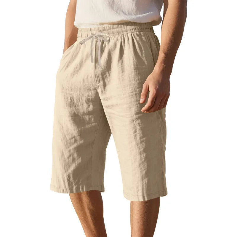 Men's loose-fit linen shorts in a solid colour with a drawstring waist and cropped leg length.