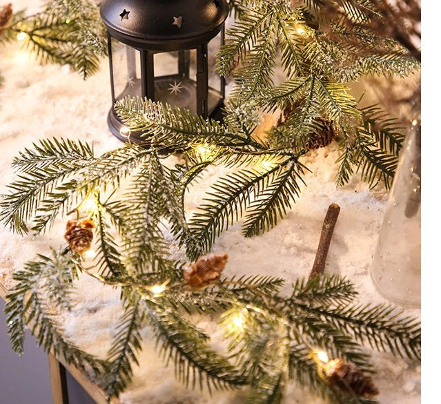 Decorative copper leaf string lights with rattan and pine needle accents, creating a cozy, festive atmosphere