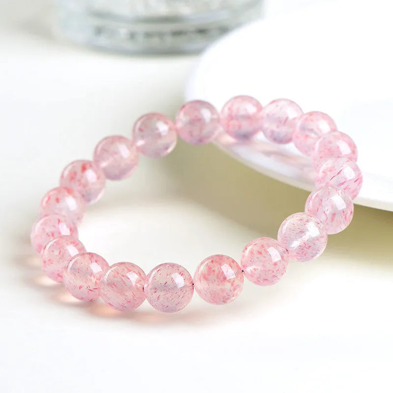 Unisex white strawberry quartz bracelet with round 10mm geometric beads on a string.