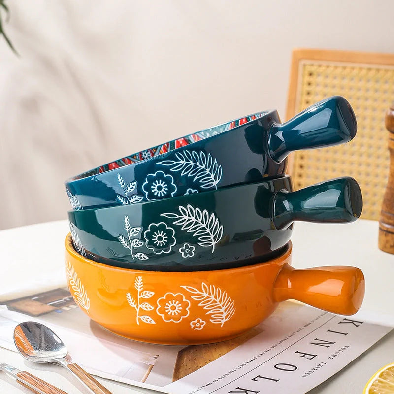 Elegant ceramic bowls with floral handles in blue, red, and green glazed finishes, perfect for serving salads and desserts