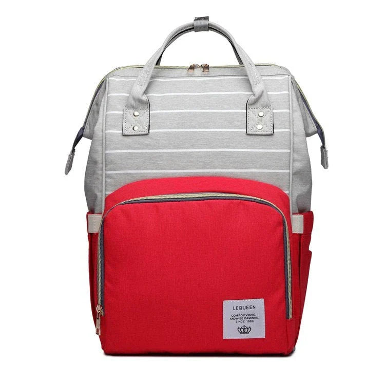 Stylish maternity diaper bag in various colors, featuring a paper bag design, separate bottle compartment, and discreet breastfeeding button.