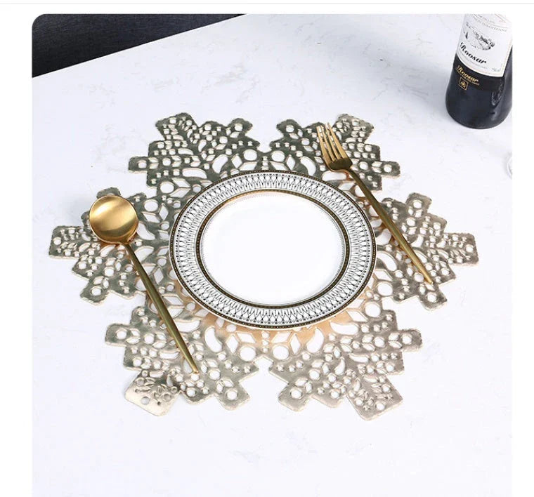 Snowflake-patterned heat-resistant placemats in gold and silver colors, ideal for holiday table settings and decor