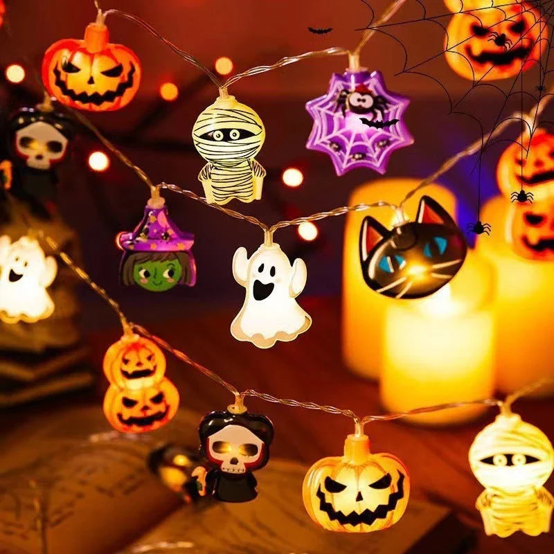 Battery-powered LED Halloween lights in various spooky designs including pumpkins, ghosts, and bats with warm white glow