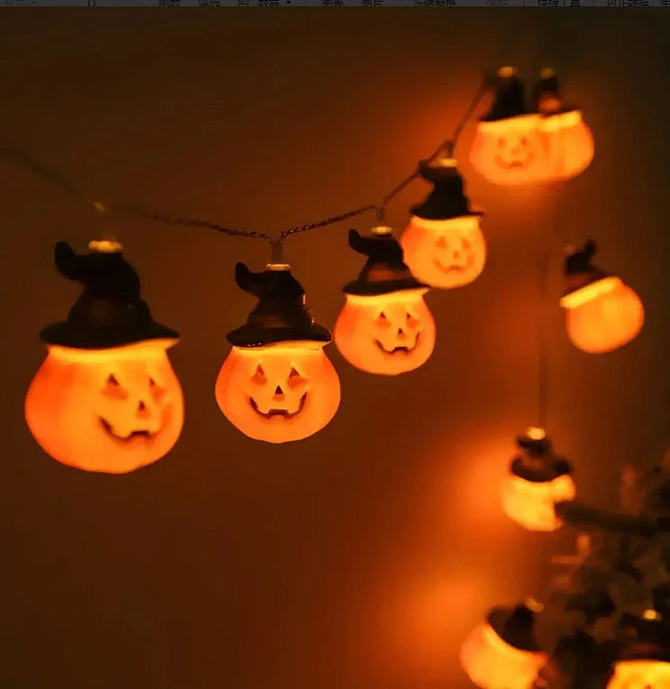 Battery-powered LED Halloween lights in various spooky designs including pumpkins, ghosts, and bats with warm white glow