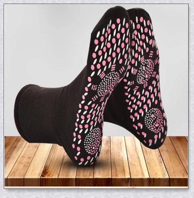 Pair of self-heating massage socks with detailed view of the acupressure-inspired soles