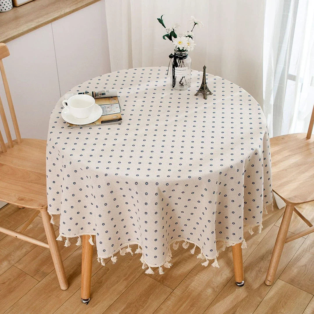 A round cotton linen tablecloth with a floral print and tassels, perfect for enhancing your dining experience.