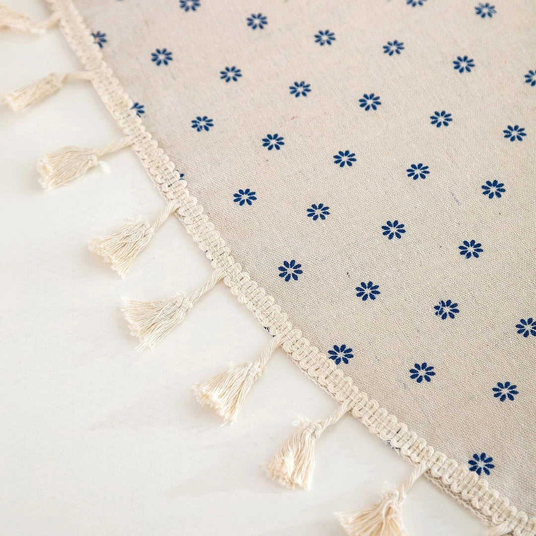 A round cotton linen tablecloth with a floral print and tassels, perfect for enhancing your dining experience.