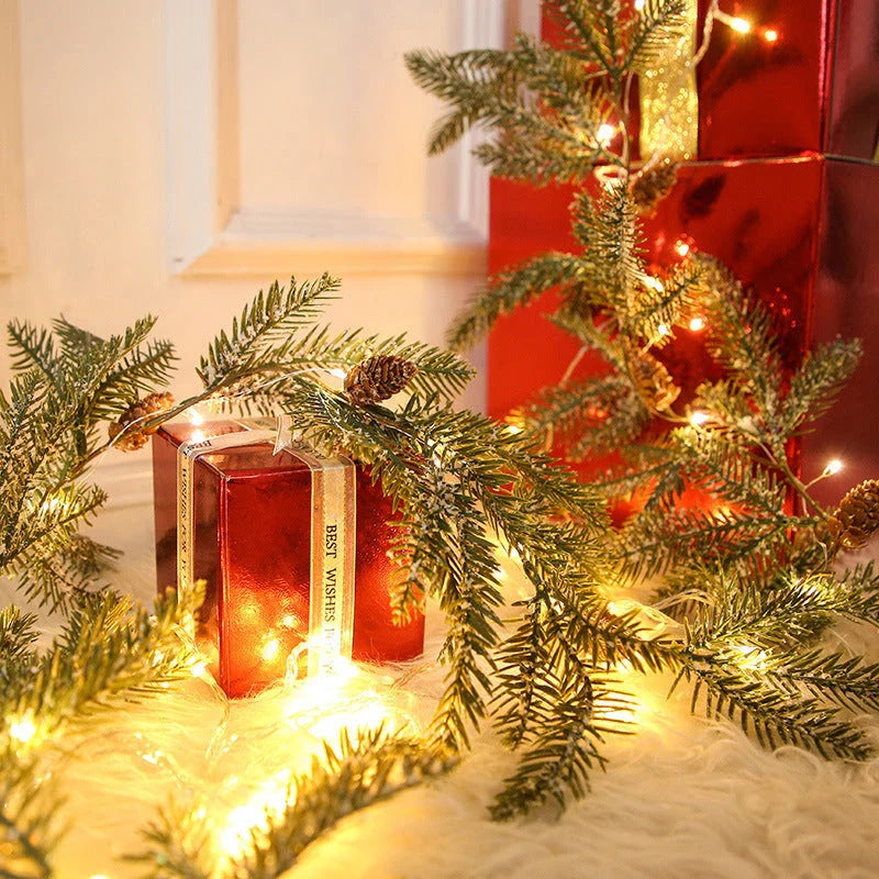 Decorative copper leaf string lights with rattan and pine needle accents, creating a cozy, festive atmosphere