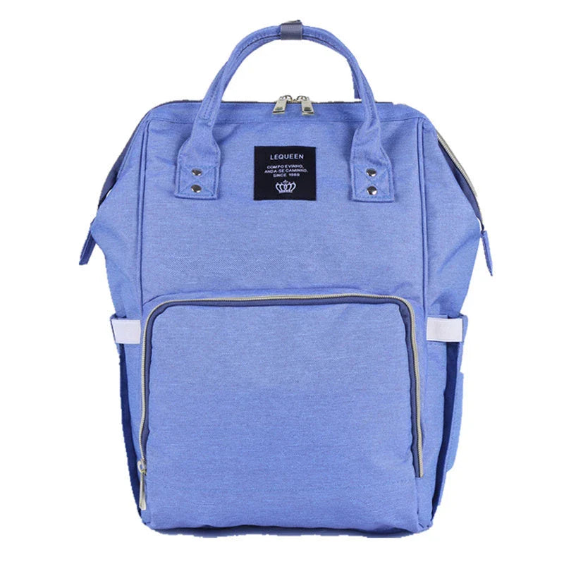 Stylish maternity diaper bag in various colors, featuring a paper bag design, separate bottle compartment, and discreet breastfeeding button.