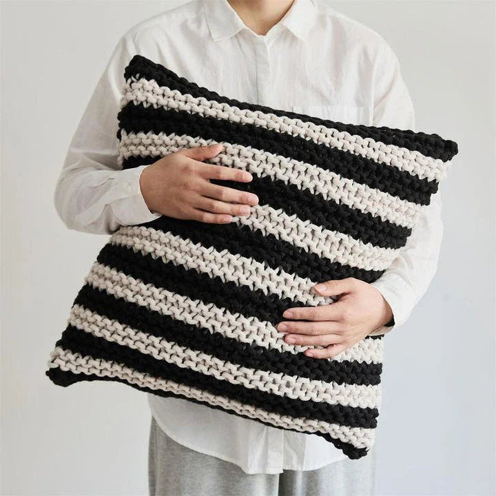 A luxurious hand-crocheted throw pillow with a chunky knit design, providing cosy comfort and elegant style for your home decor.
