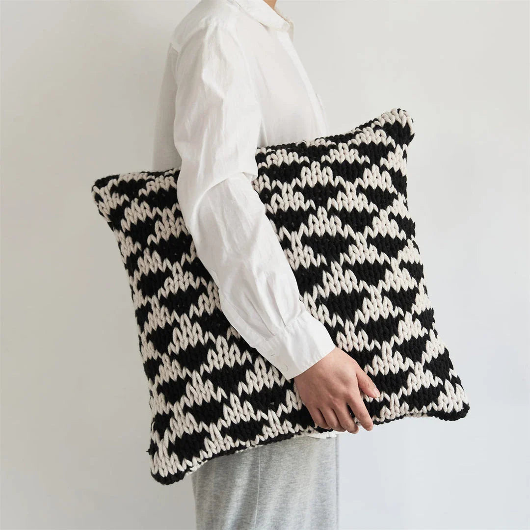 A luxurious hand-crocheted throw pillow with a chunky knit design, providing cosy comfort and elegant style for your home decor.