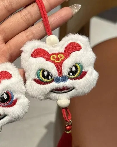Handmade blue plush lion keychain with tassels and star stone decoration.