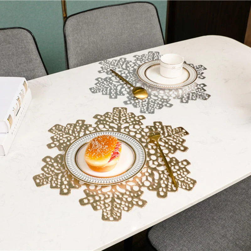 Snowflake-patterned heat-resistant placemats in gold and silver colors, ideal for holiday table settings and decor